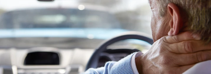 A man holding his neck in pain after an auto accident