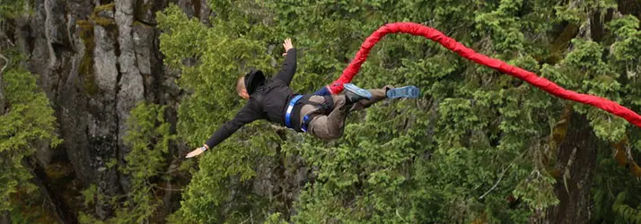 Dr. Elliot Lysyk bungee jumping in a forest