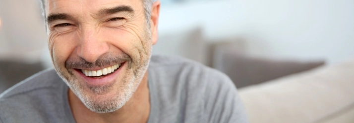 A man smiling. He has a short grey beard.