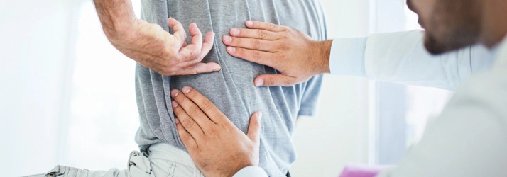 A person pointing to their mid back.