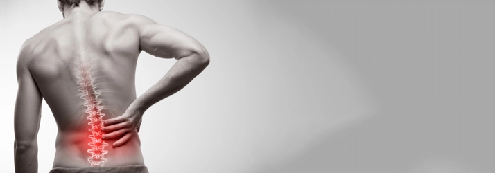 A man holding his hip. His spine is highlighted red.