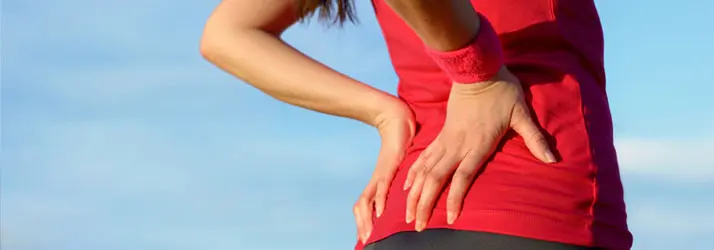 A person holding their lower back in pain.