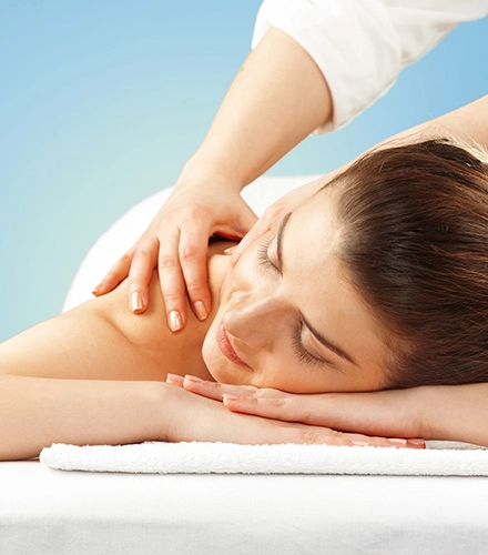 A relaxed patient with eyes closed receiving a shoulder massage