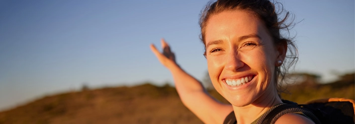 A triumphant young woman at the top of a mountain