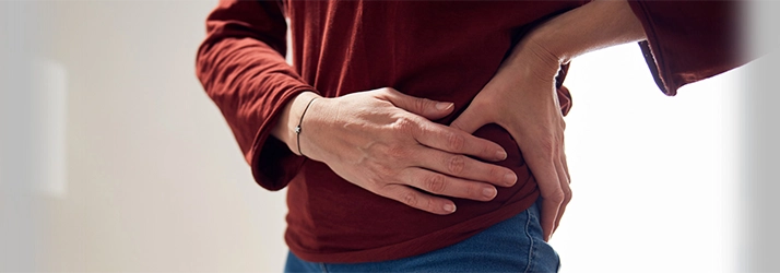 A person holding their hip in pain.