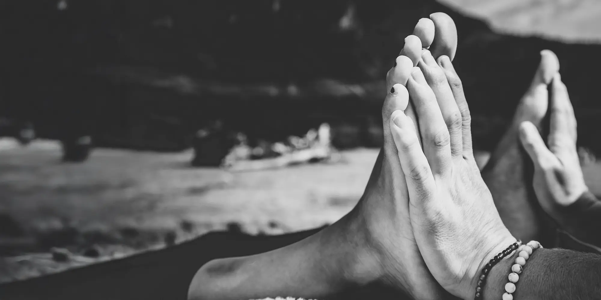 A reflexologist's hands against a patient's feet